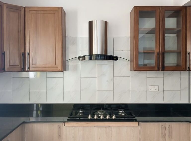 Kitchen with wooden cabinets and a Newmatic curved chimney hood.