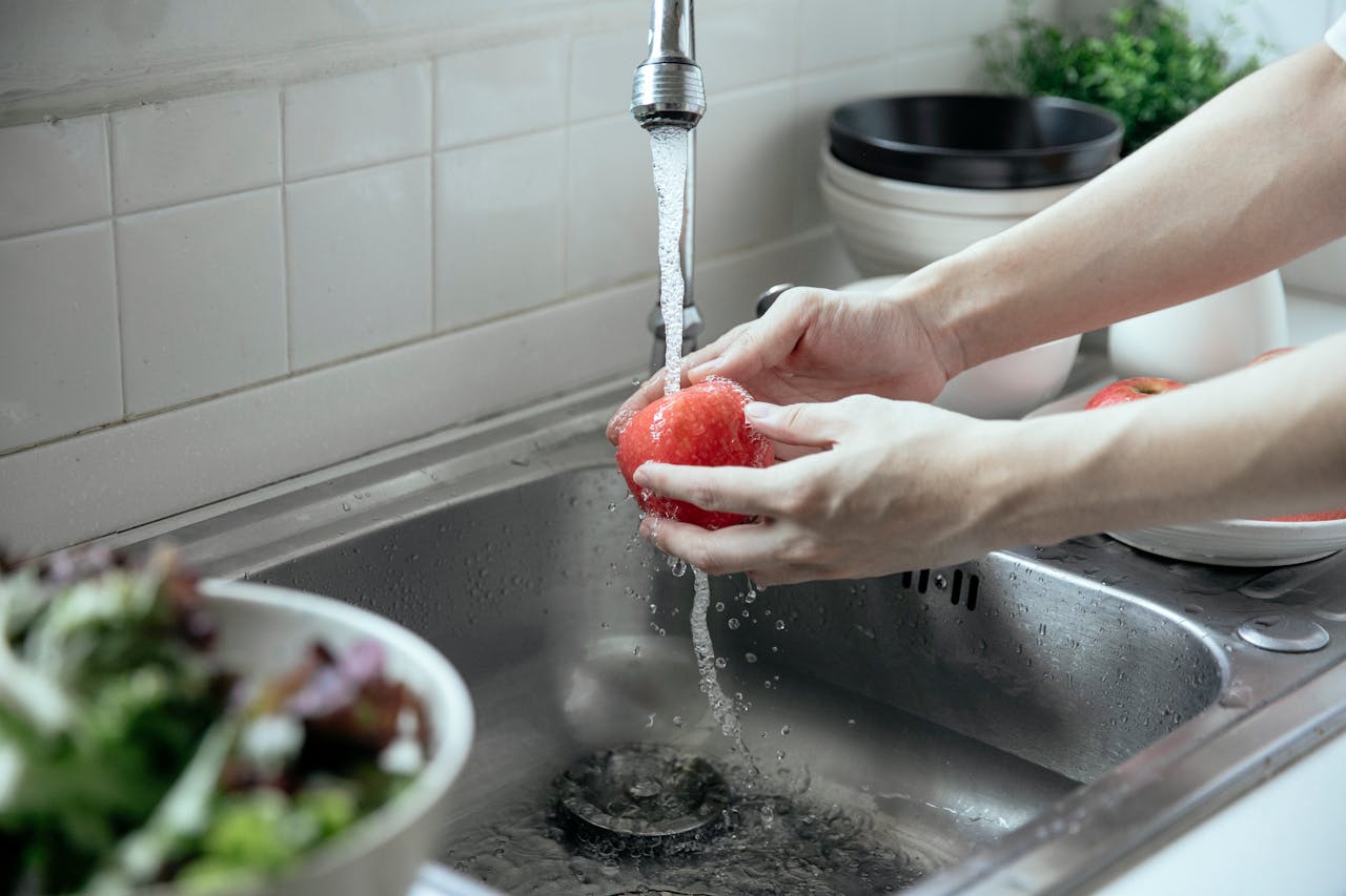 Washing an Apple on a Kitchen Sink with Overflow Outlet